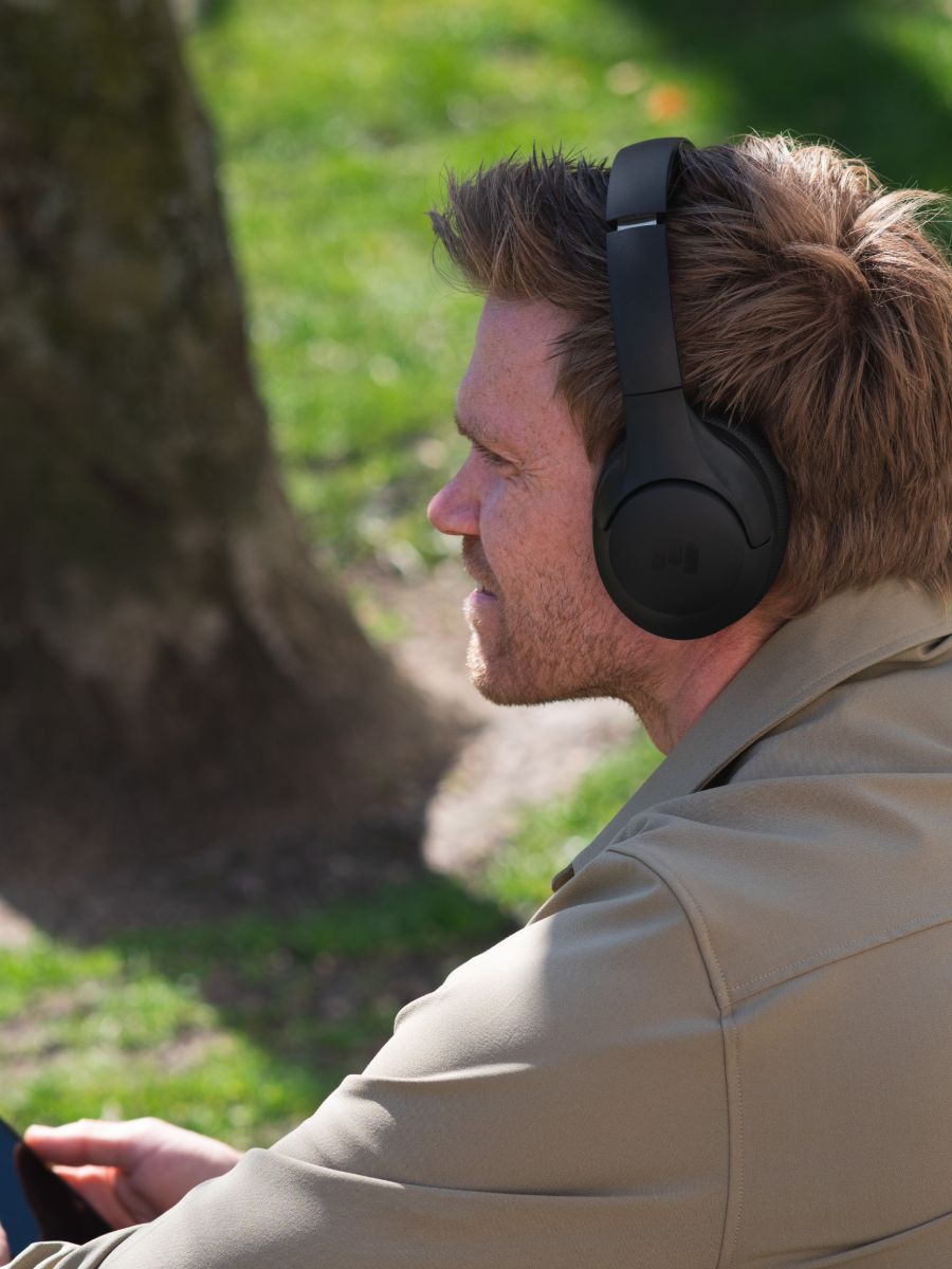 Man wearing MIIEGO headphones outdoors