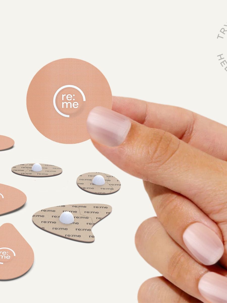 Hand holding a re:me acupressure plaster